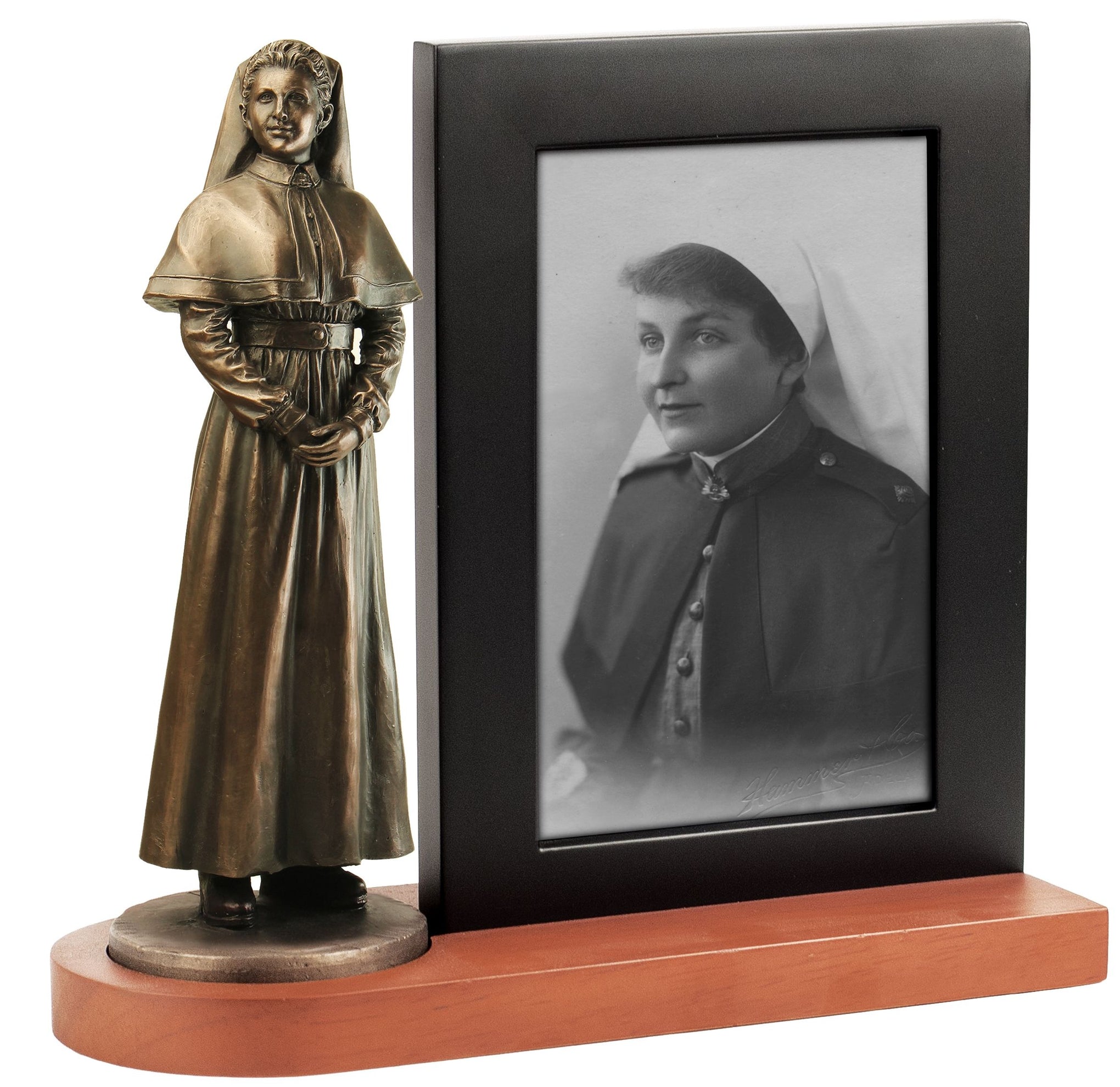 Bronze statue of a woman in a long dress next to a framed black and white photo of another woman in a similar outfit.