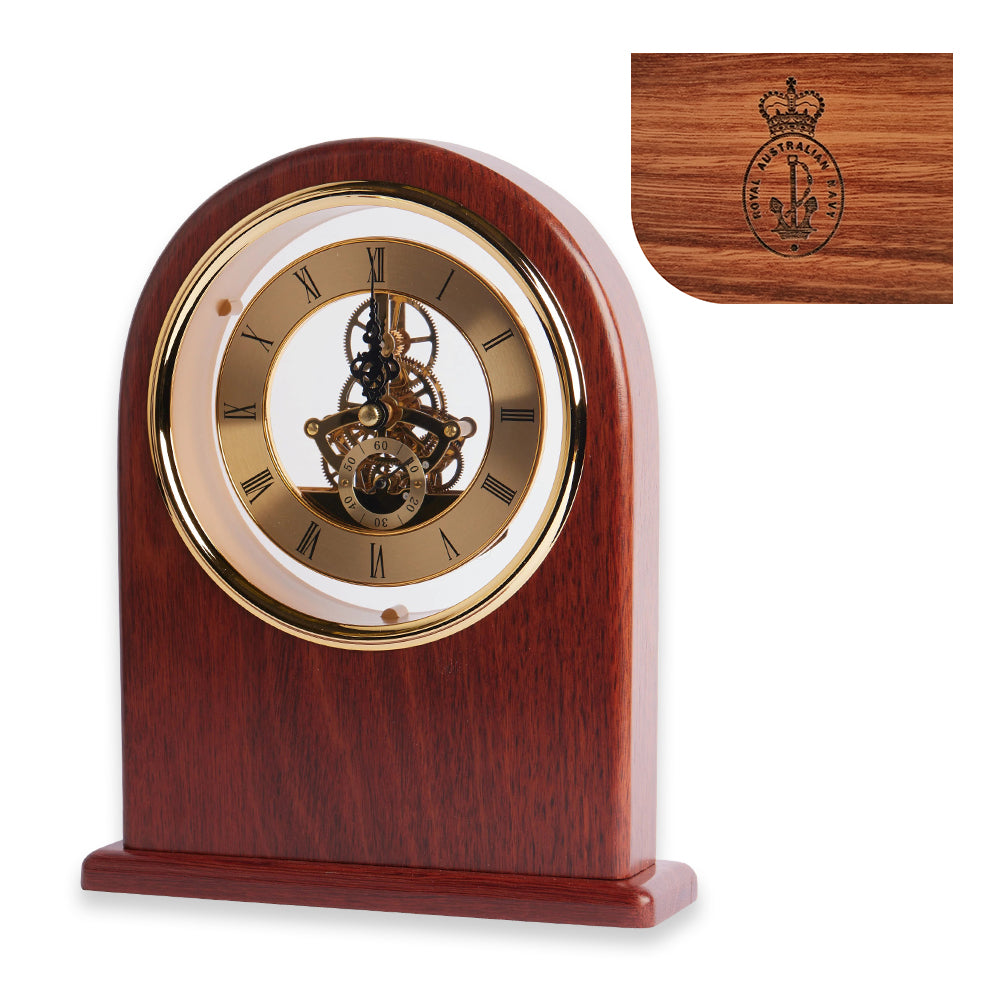 A wooden mantle clock with a brass-tone mechanism, featuring an arched design and a Royal Australian Navy badge laser engraved on the wood.
