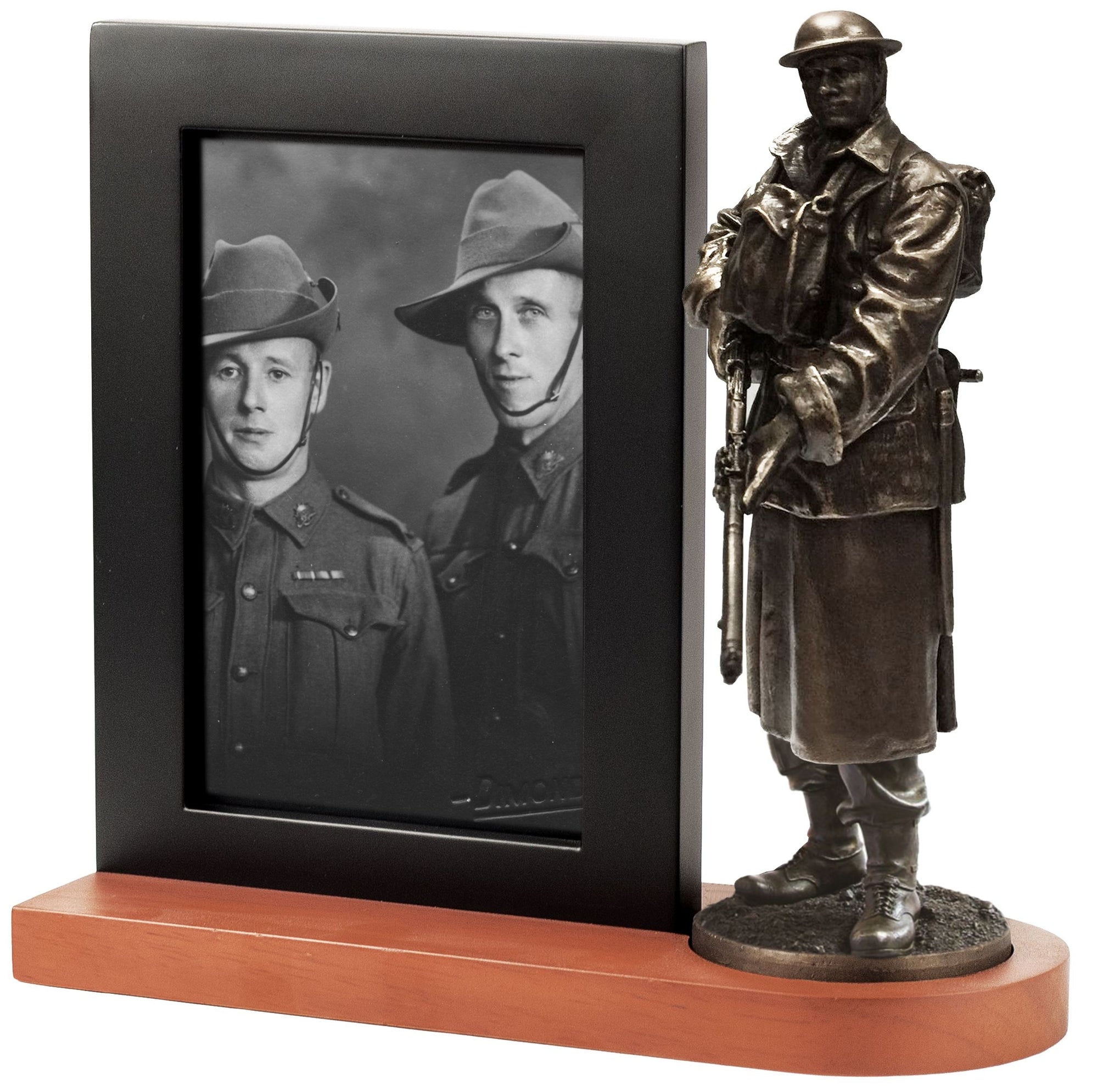 Bronze statue of a soldier next to a framed black and white photo of two soldiers on a wooden base.